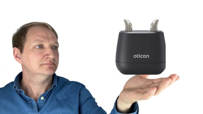 Darstellung wie Maximilian Bauer (Mac Clinical Audiology) das Oticon Intent Hörgerät in der Hand hält.