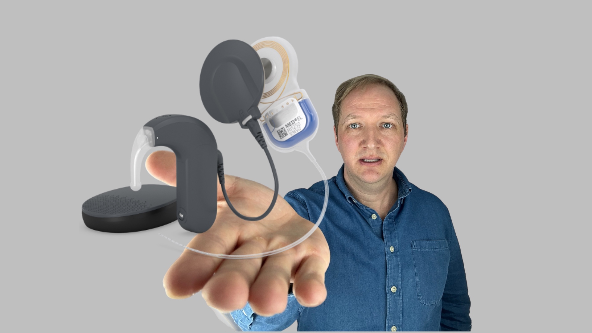 Mann hält Cochlear Implantat in der Hand
