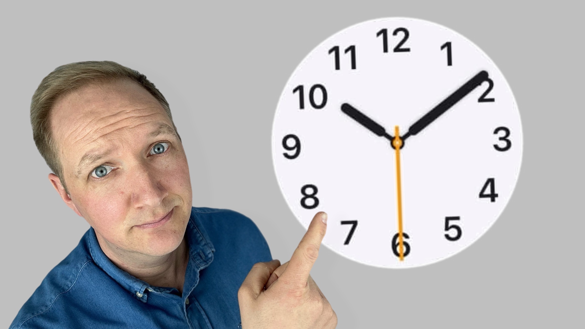 Maximilian Bauer zeigt mit Finger vor grauem Hintergrund auf ein Apple Uhr Zifferblatt